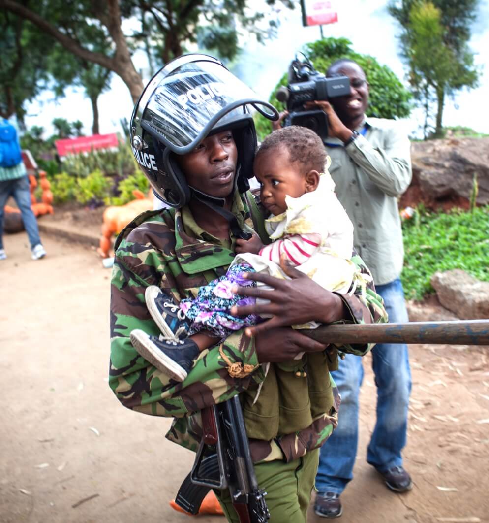 African soldier carrying baby whilst being filmed